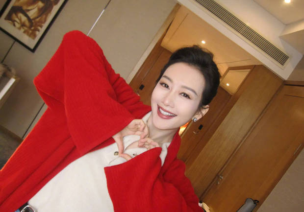 王鸥穿大红外套明艳动人 对镜头甜笑比心超养眼(图1)